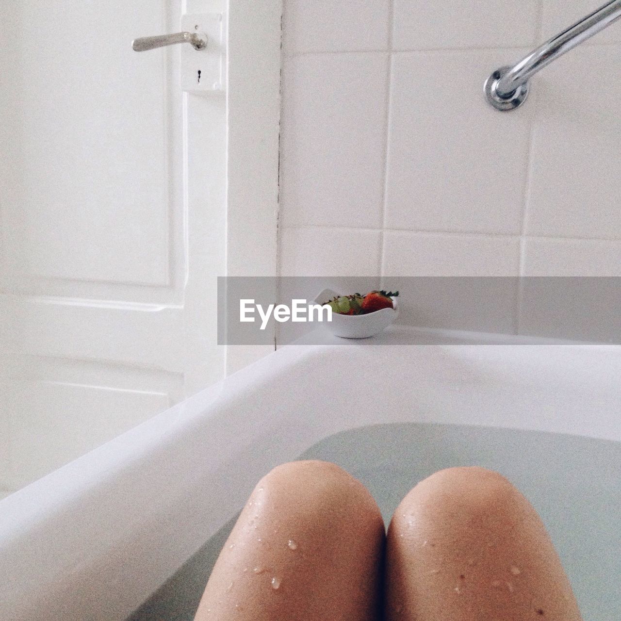 Midsection of woman bathing in bathtub