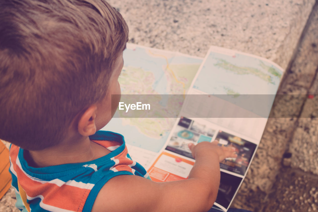 High angle view of boy looking at world map