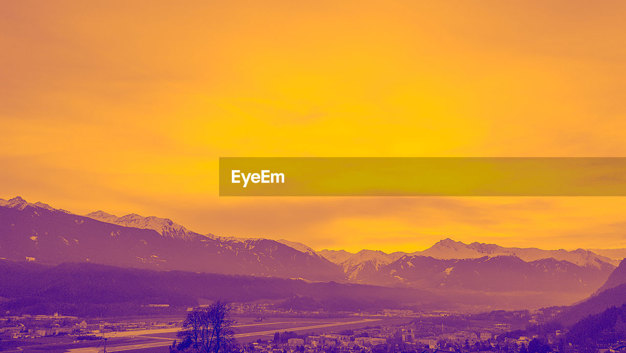 SCENIC VIEW OF MOUNTAINS AGAINST ORANGE SKY