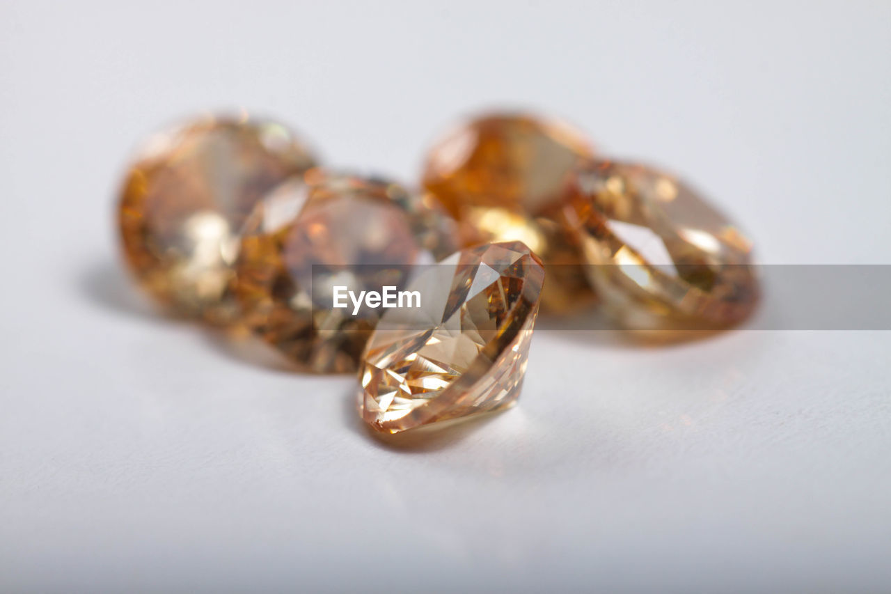 CLOSE-UP OF RINGS ON TABLE AGAINST WHITE BACKGROUND