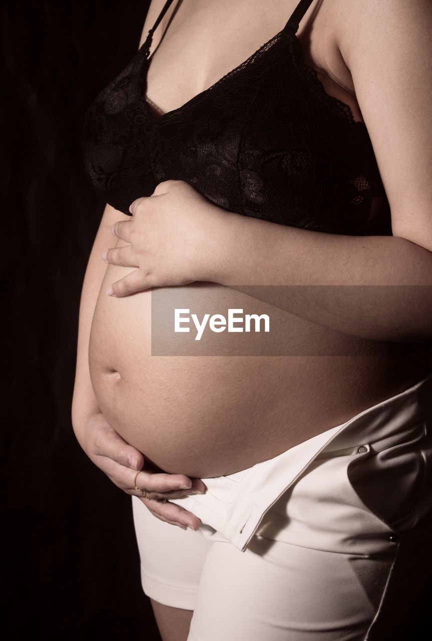 MIDSECTION OF WOMAN TOUCHING HAIR