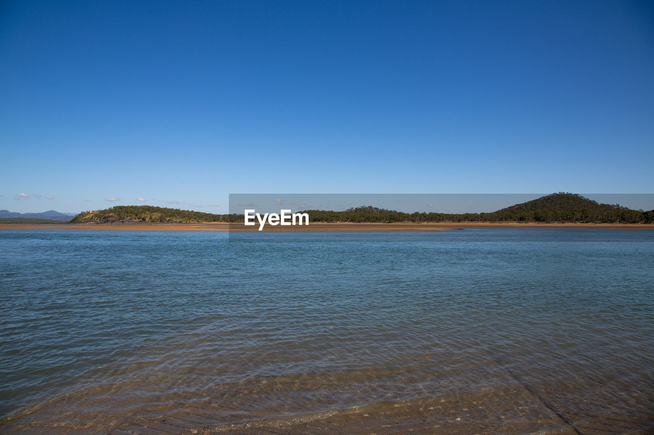 Scenic view of lake against clear blue sky