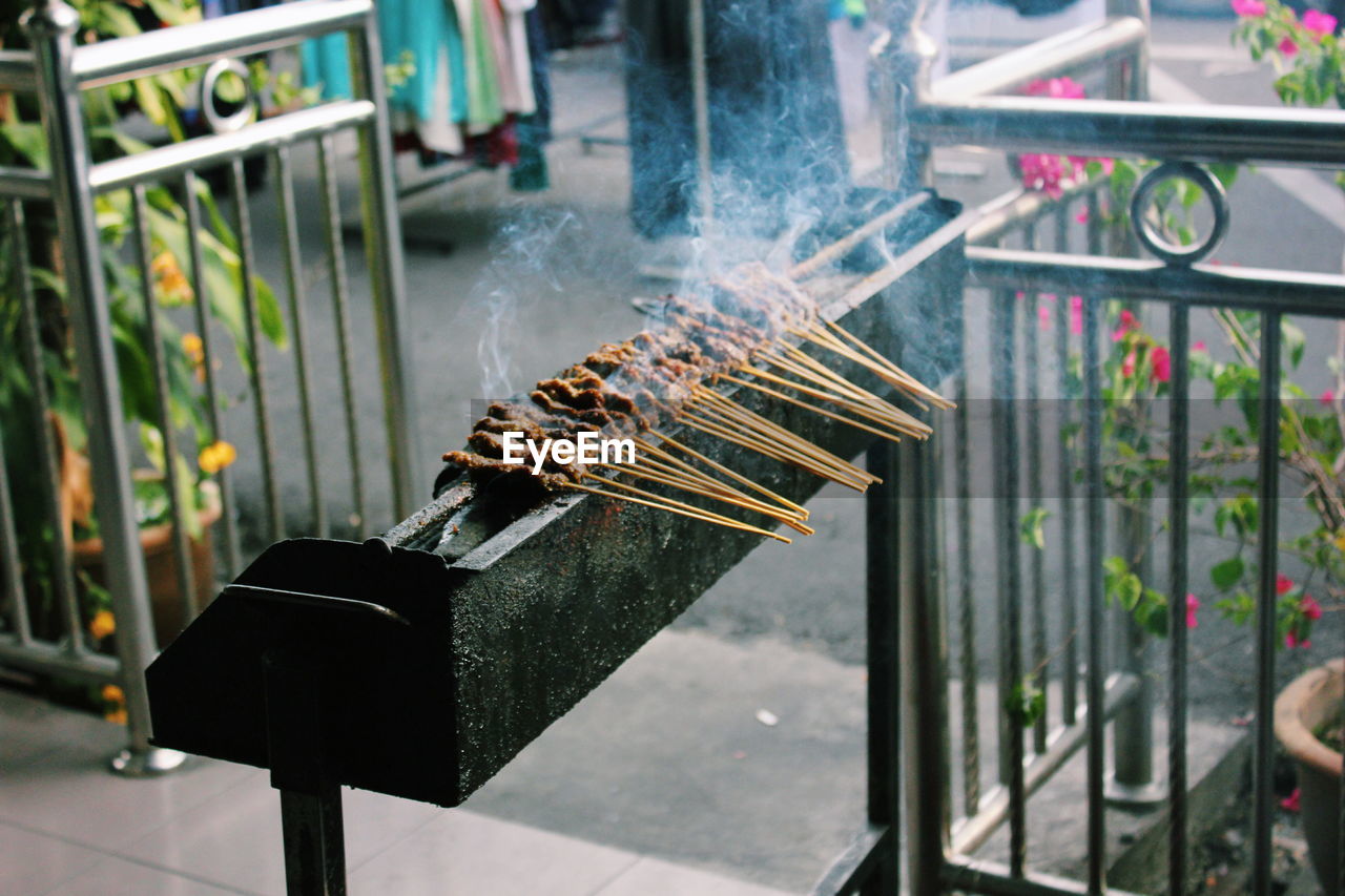 High angle view of satay cooking on barbeque at market stall