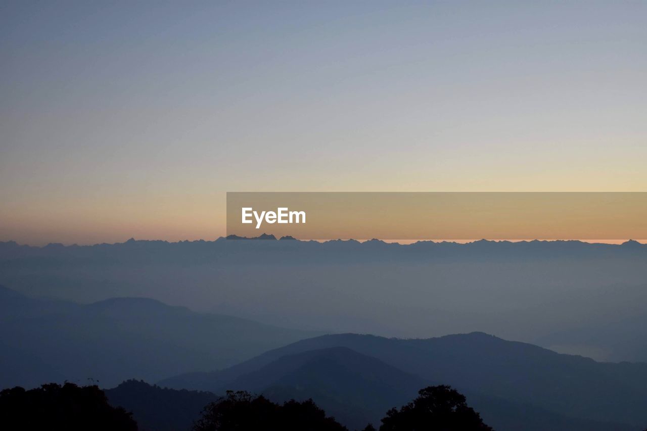 Scenic view of silhouette mountains against sky during sunset