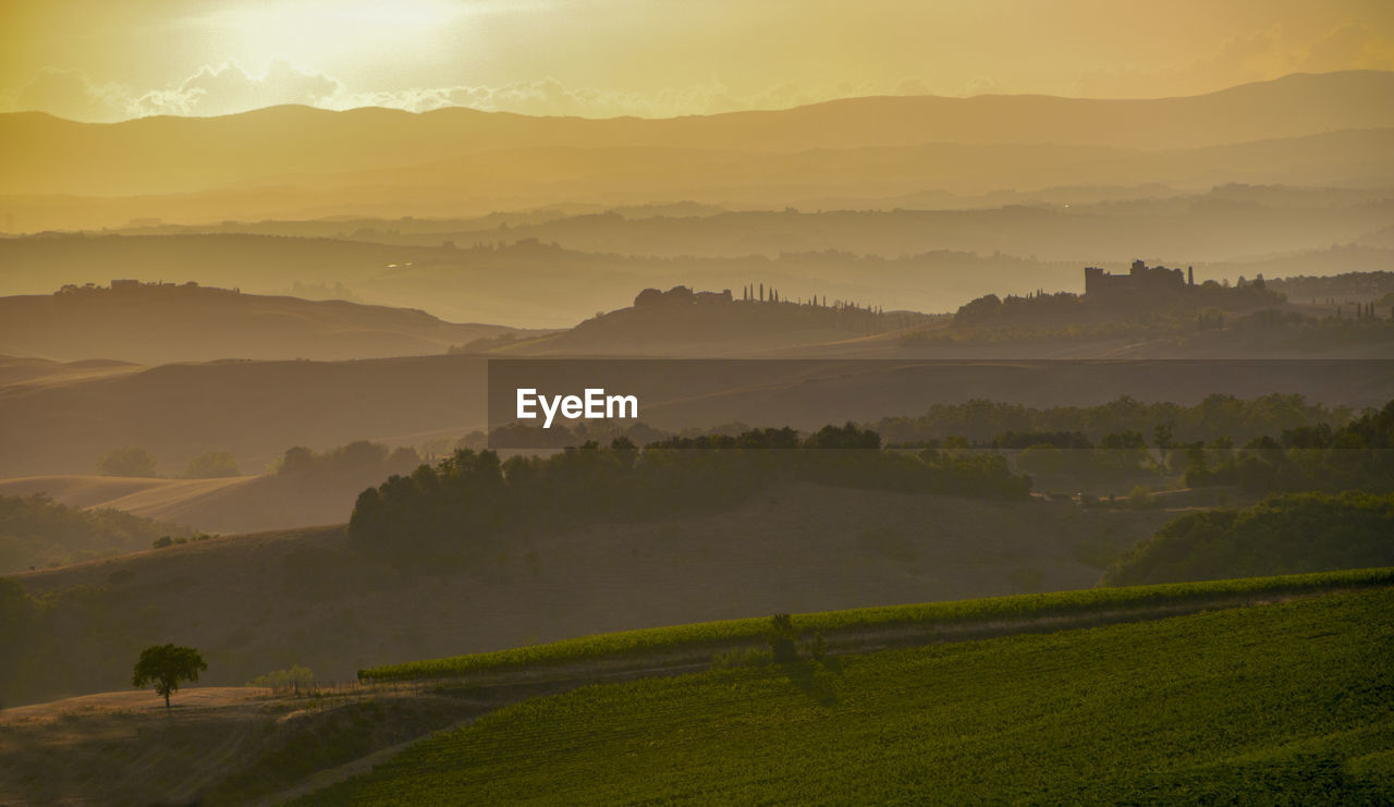 SCENIC VIEW OF FARM AGAINST SKY DURING SUNSET