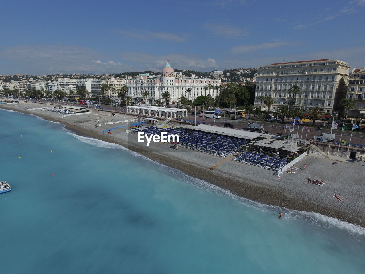 HIGH ANGLE VIEW OF SWIMMING POOL IN CITY AGAINST SKY