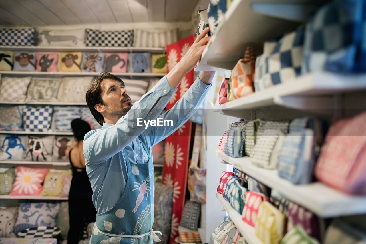 Male owner with colleague working in fabric shop