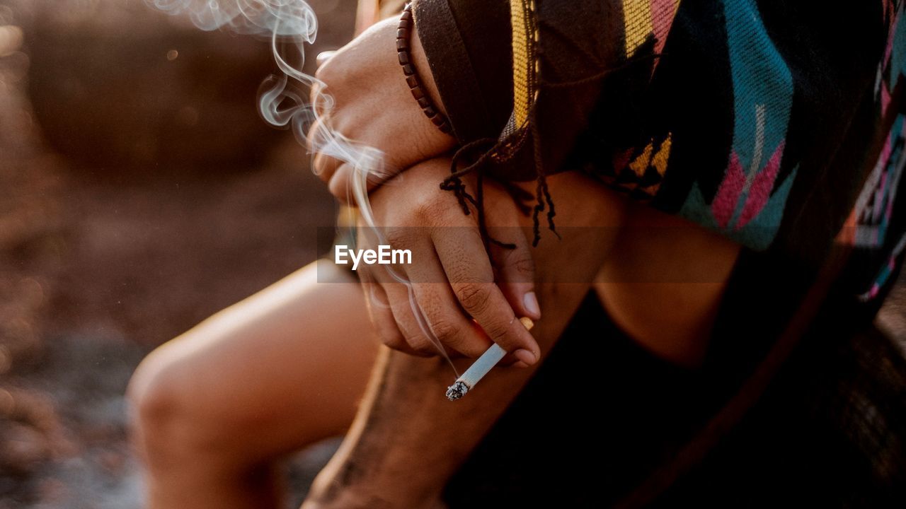 Close-up of woman smoking cigarette outdoors