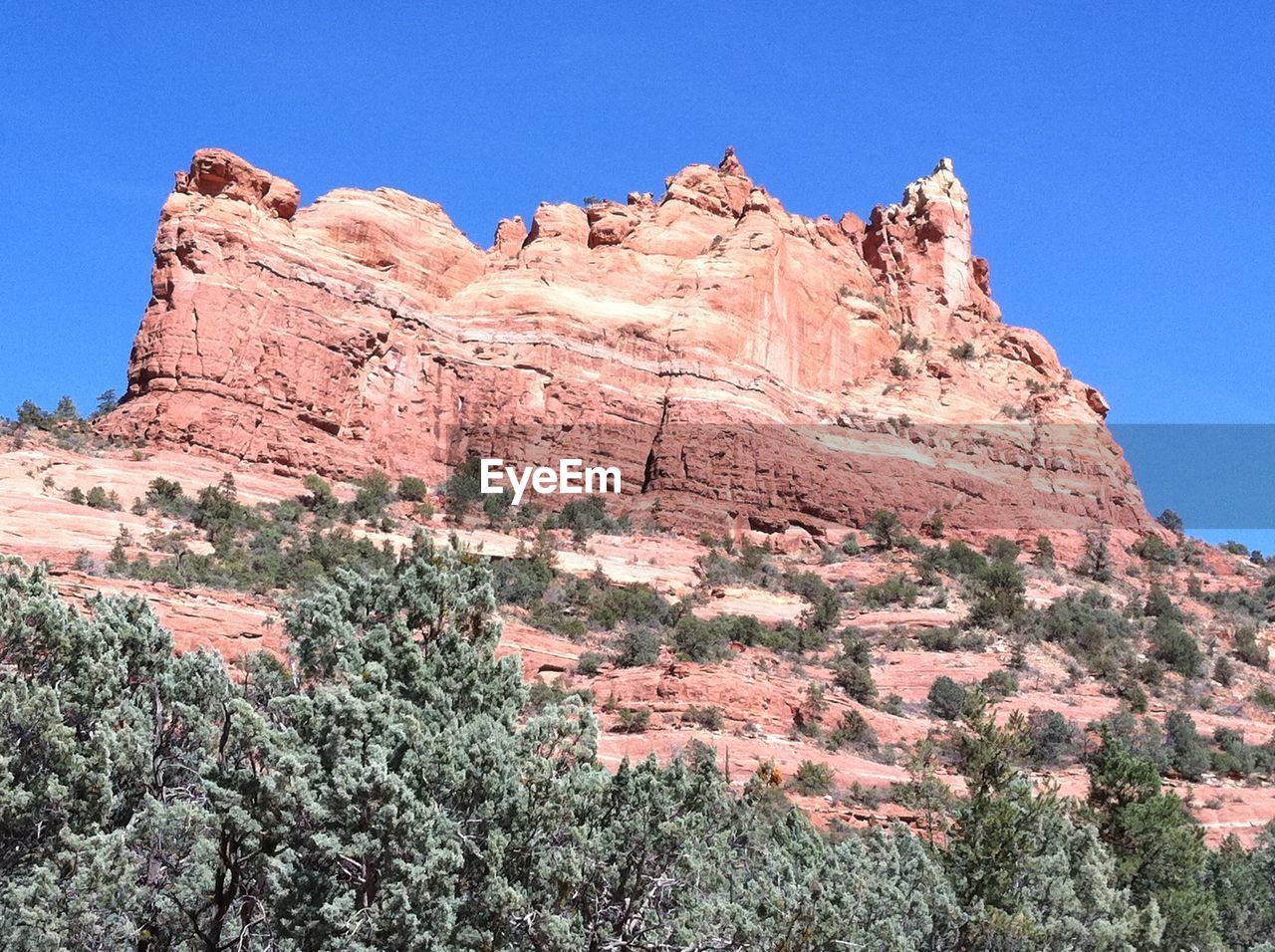 Low angle view of rocky mountains against clear blue sky