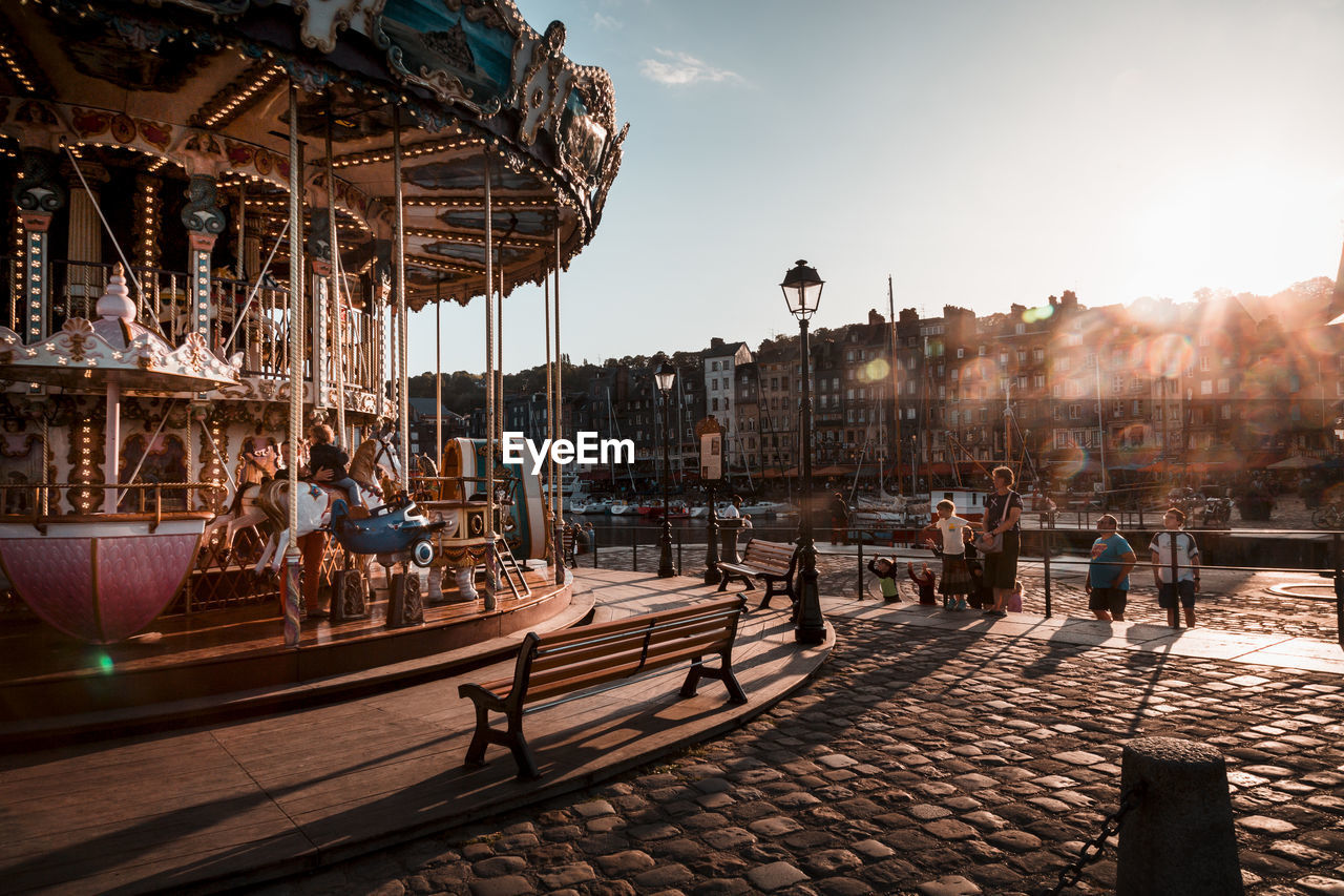 PEOPLE AT AMUSEMENT PARK AGAINST SKY