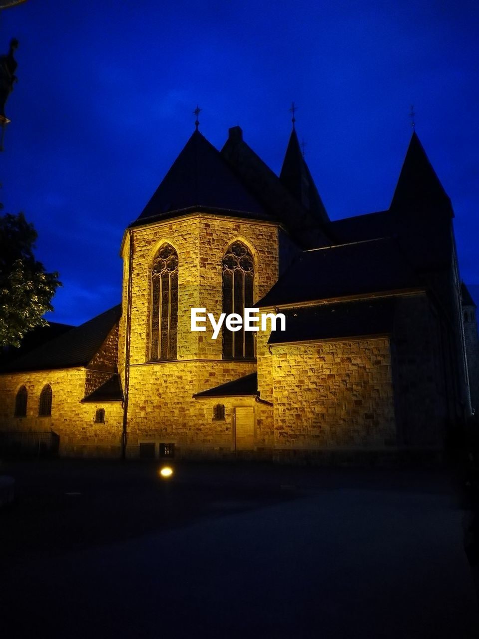 LOW ANGLE VIEW OF ILLUMINATED BUILDING AT NIGHT