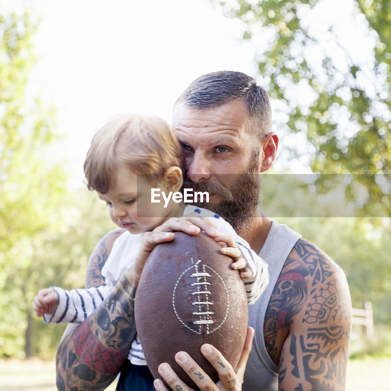 Father and son with rugby ball at park