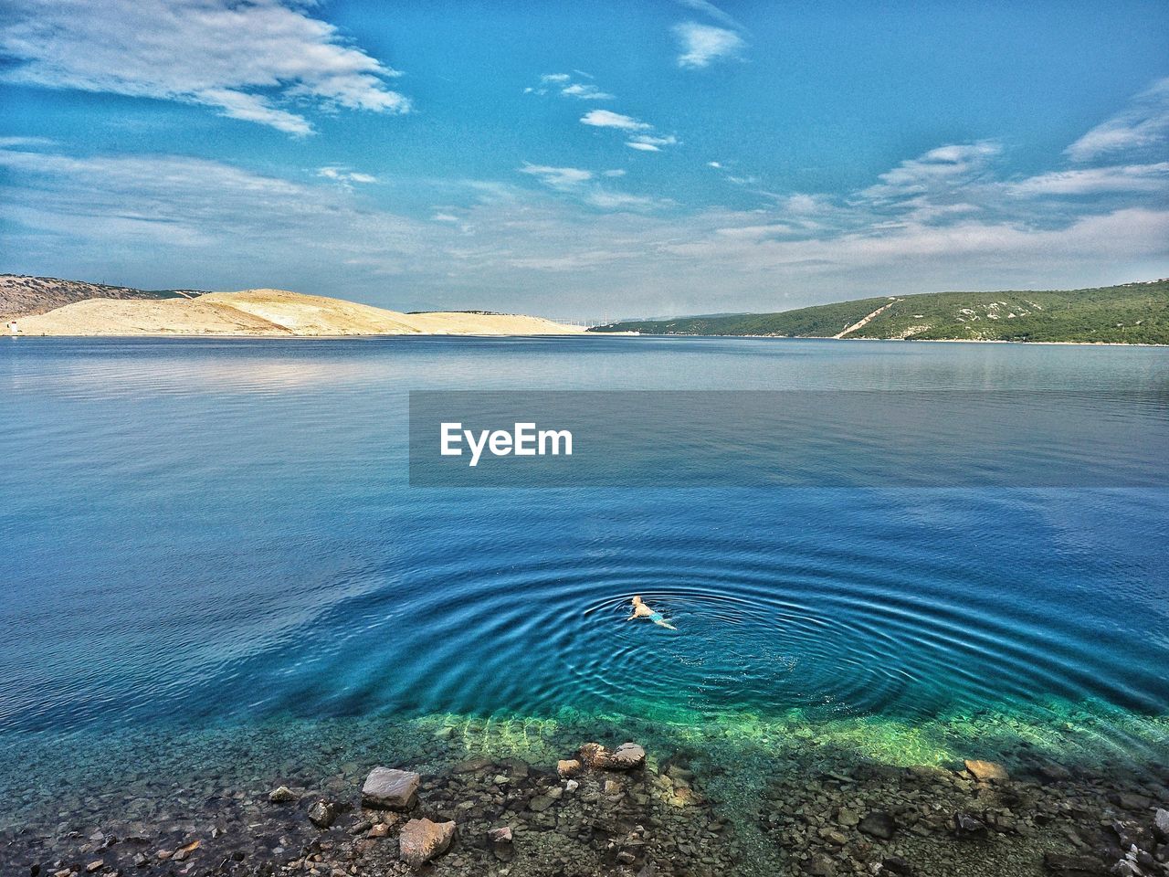 Man swimming in lake against sky