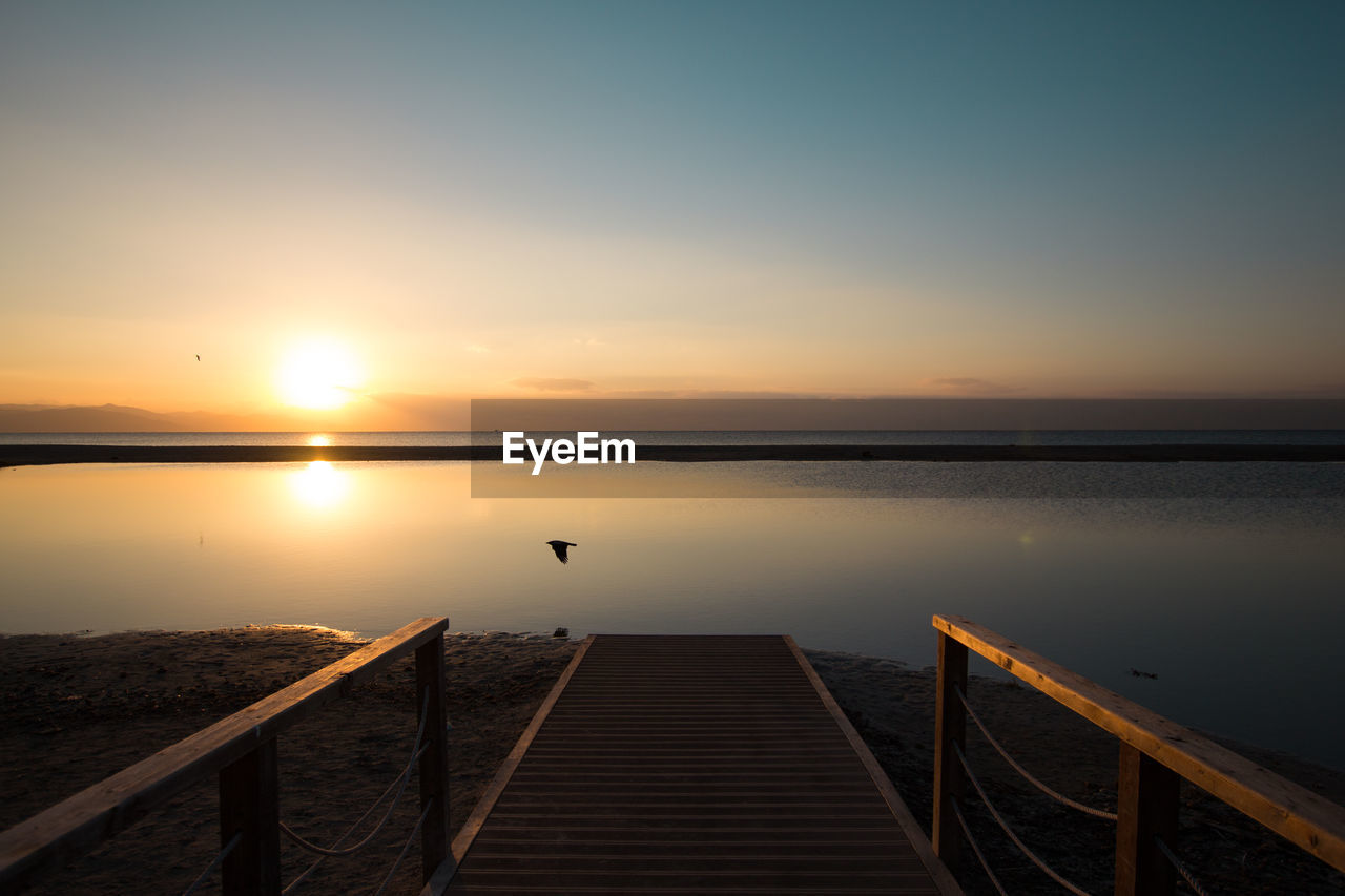 SCENIC VIEW OF LAKE AGAINST ORANGE SKY