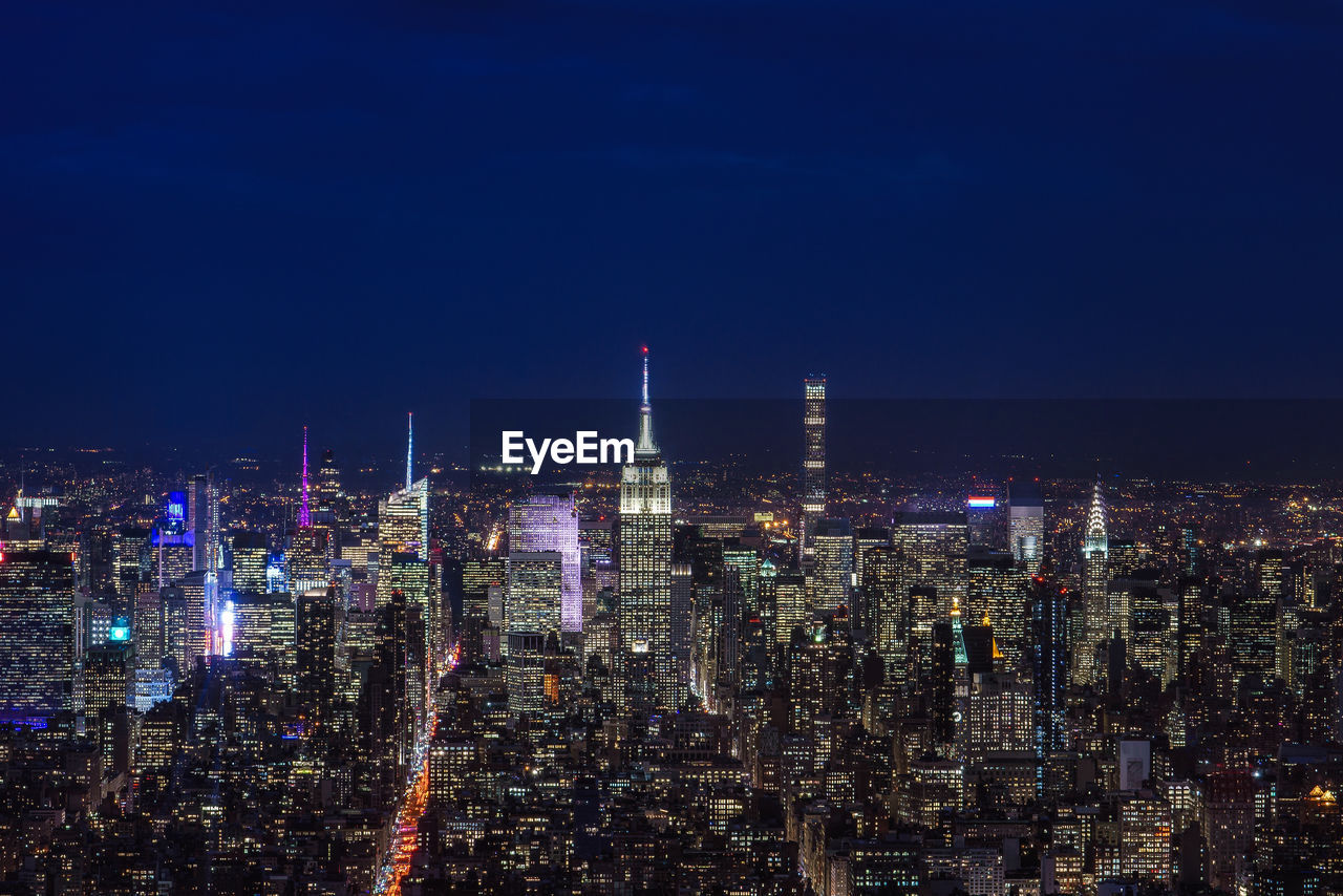 Illuminated cityscape against sky at night