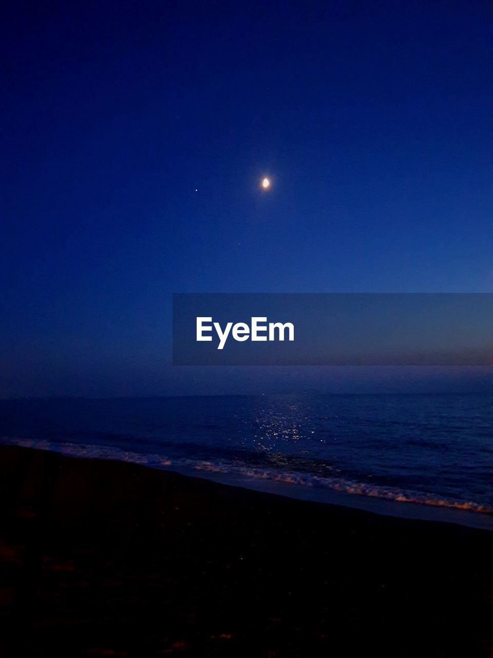 SCENIC VIEW OF SEA AGAINST SKY AT NIGHT