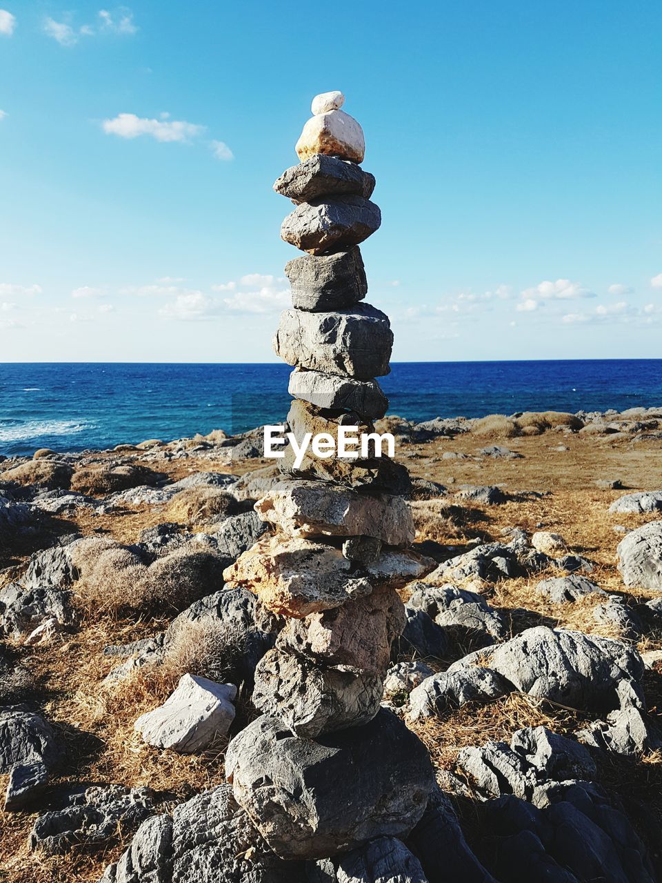 Close-up of stack of rocks by sea against sky