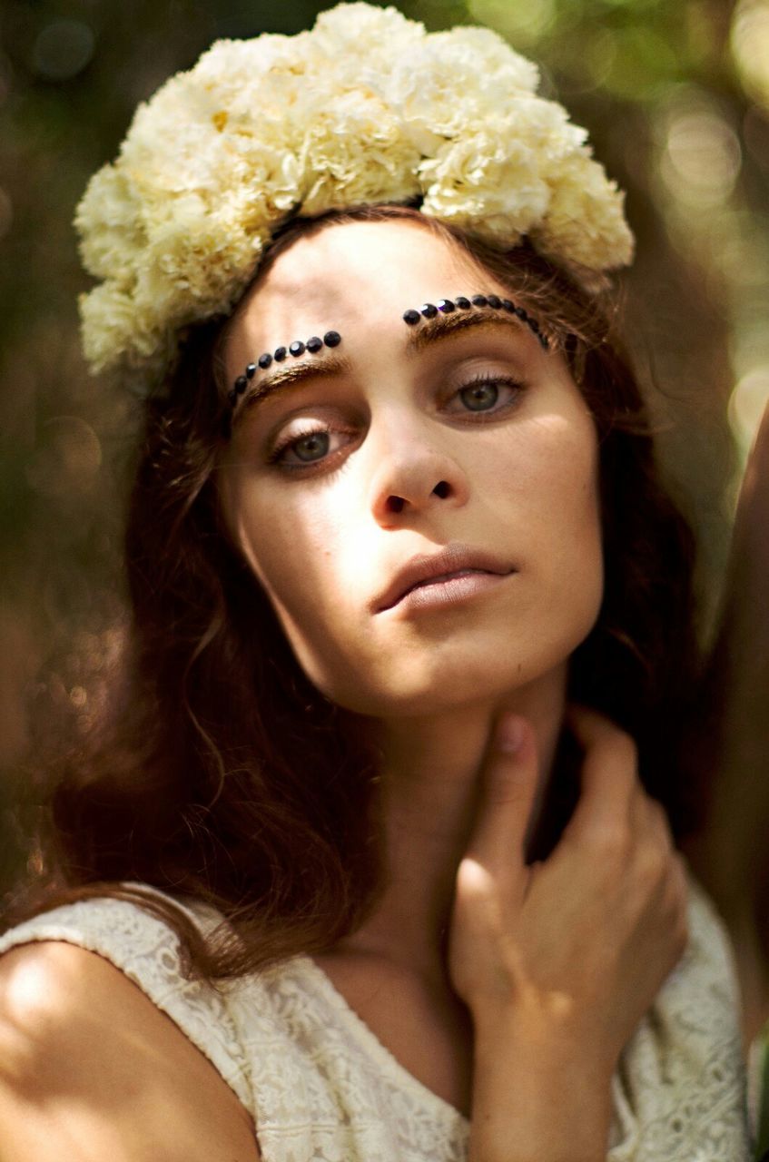 Close-up portrait of beautiful woman with flowers in hair