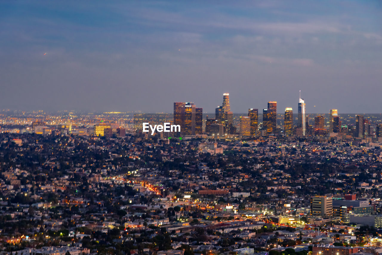 Illuminated cityscape against sky at night