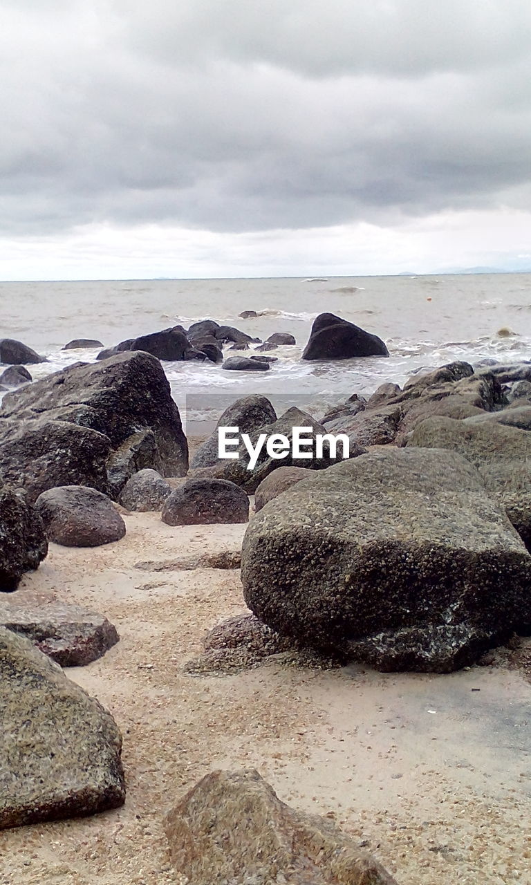 ROCKS ON BEACH AGAINST SKY