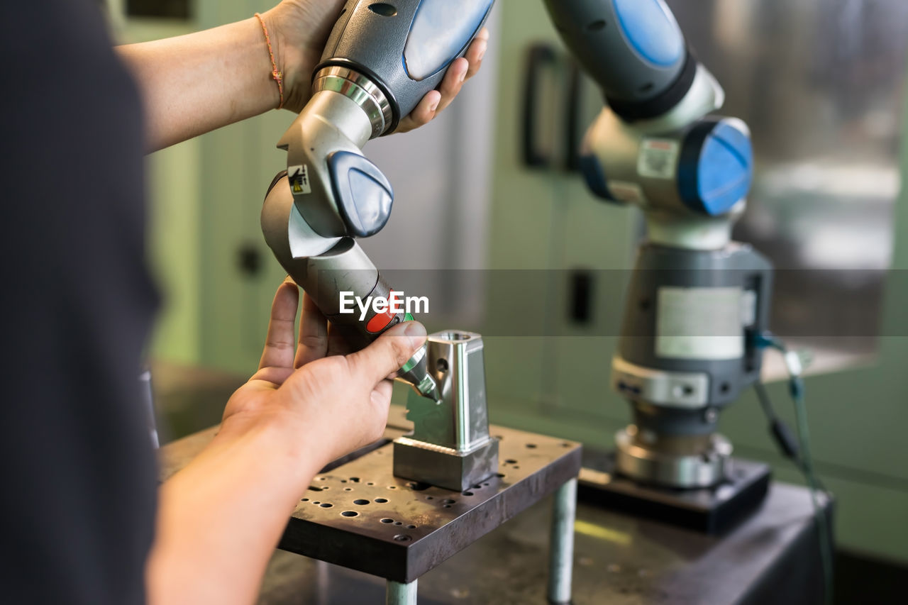 cropped hand of man repairing machine