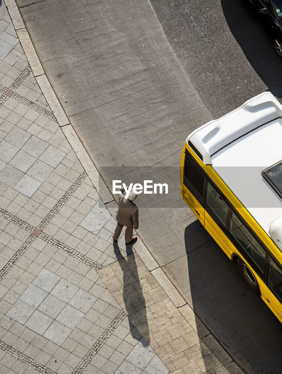 High angle view of man standing on sidewalk in city