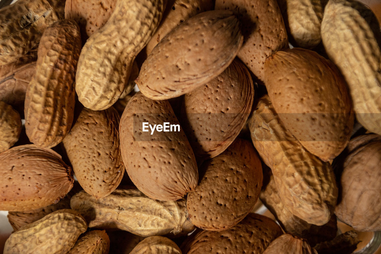 Almonds in shell and peanuts . dry food background details.