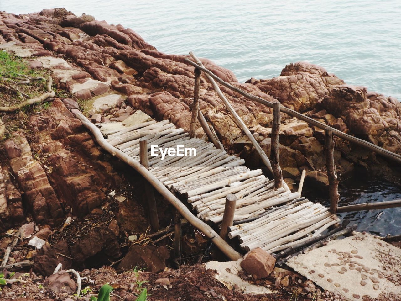 HIGH ANGLE VIEW OF ABANDONED WOOD ON SHORE