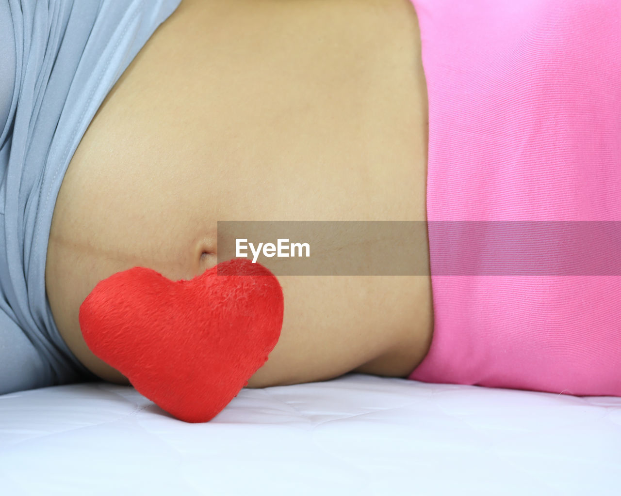 Heart shape against belly of pregnant woman