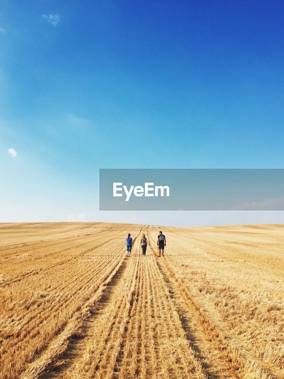 Family standing on field against sky