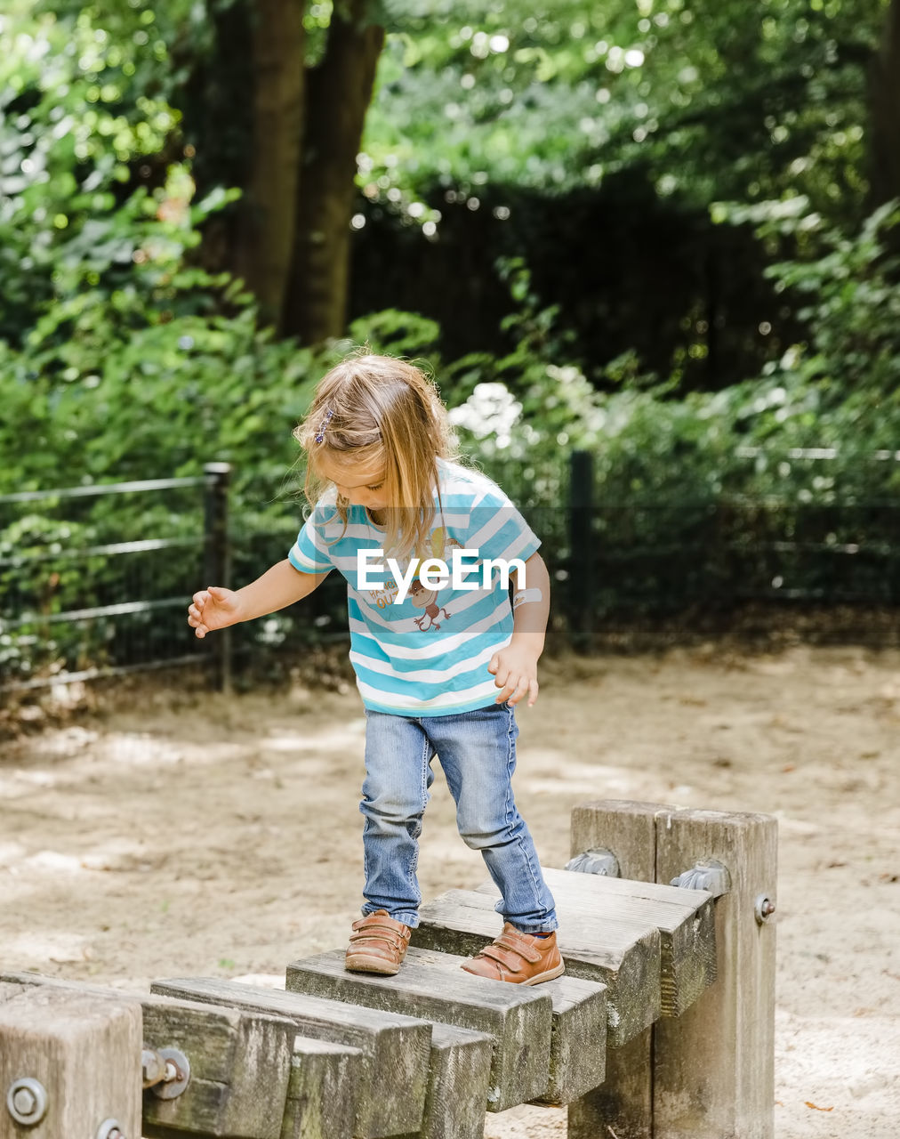 Girl walking on wood in park