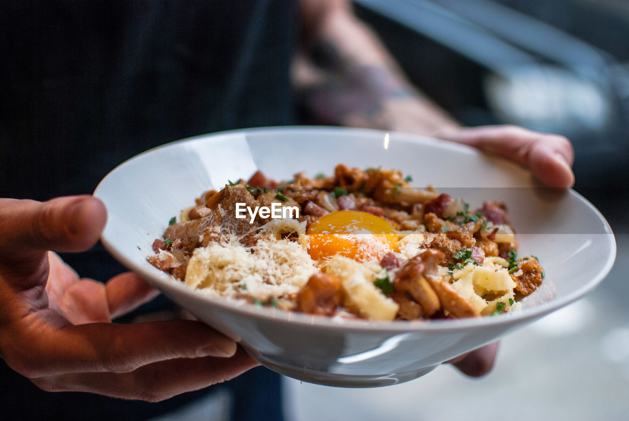 Cropped image of person holding food in bowl