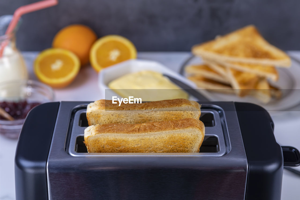 Slices of great toast coming out of the toaster. healthy breakfast food and heating technology
