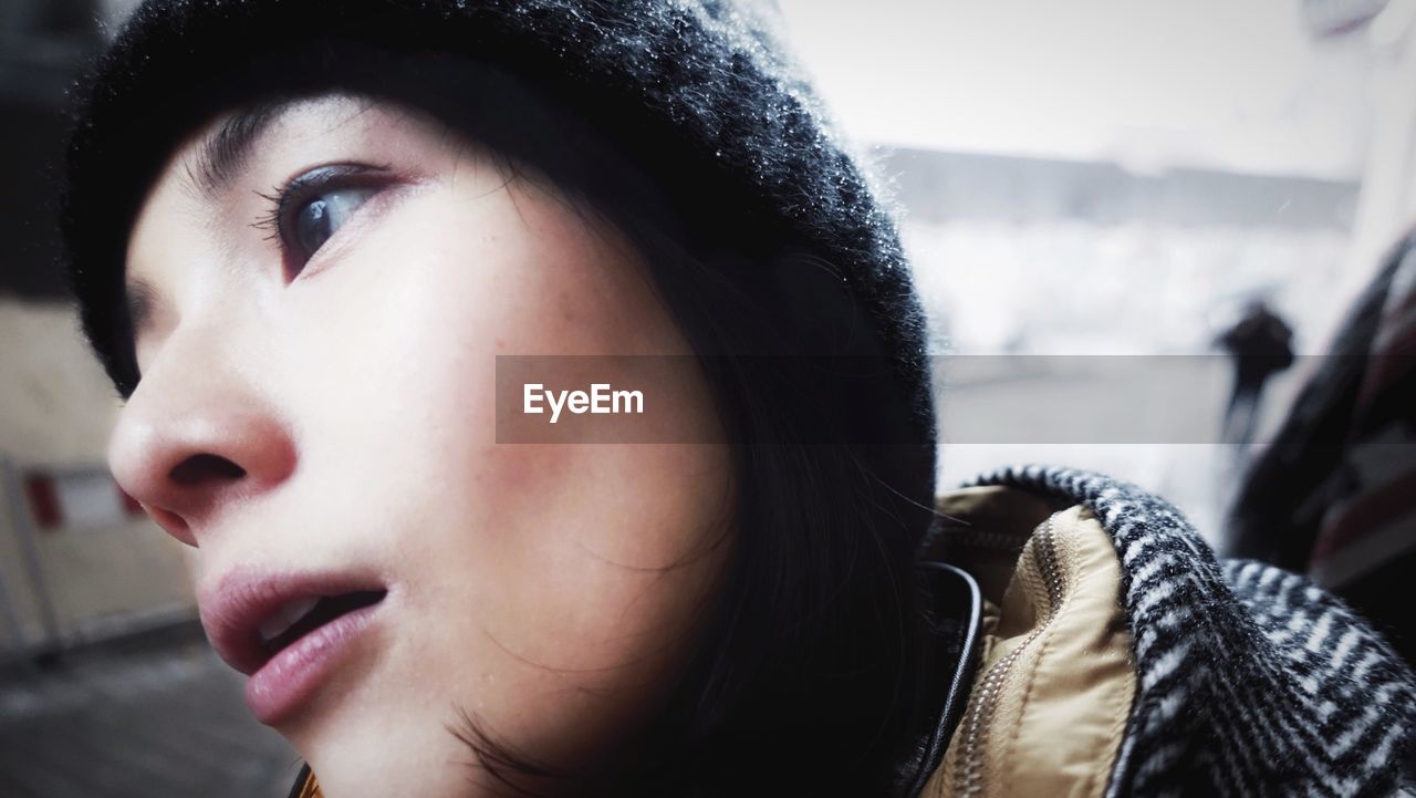 Close-up of young woman wearing knit hat in city during winter