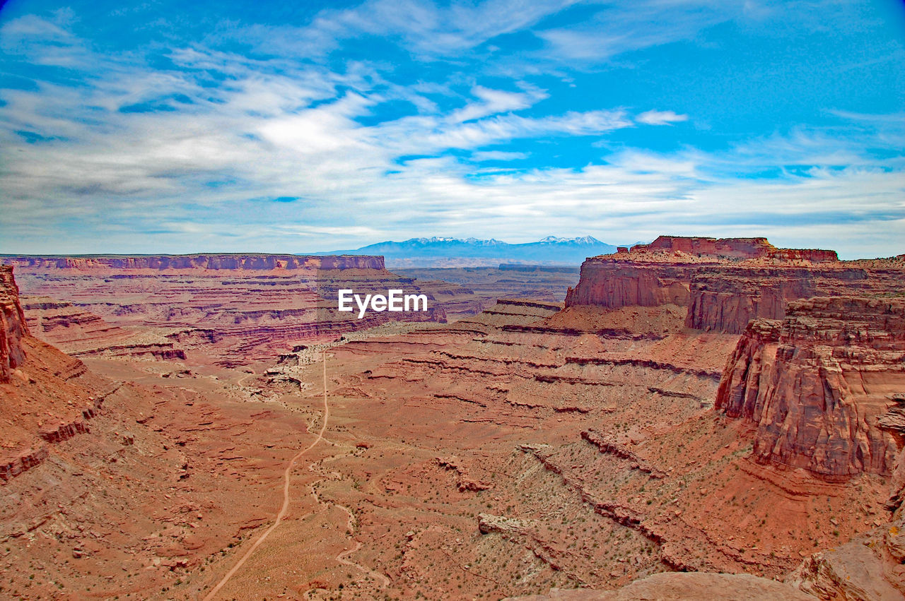 Scenic view of desert landscape against cloudy sky