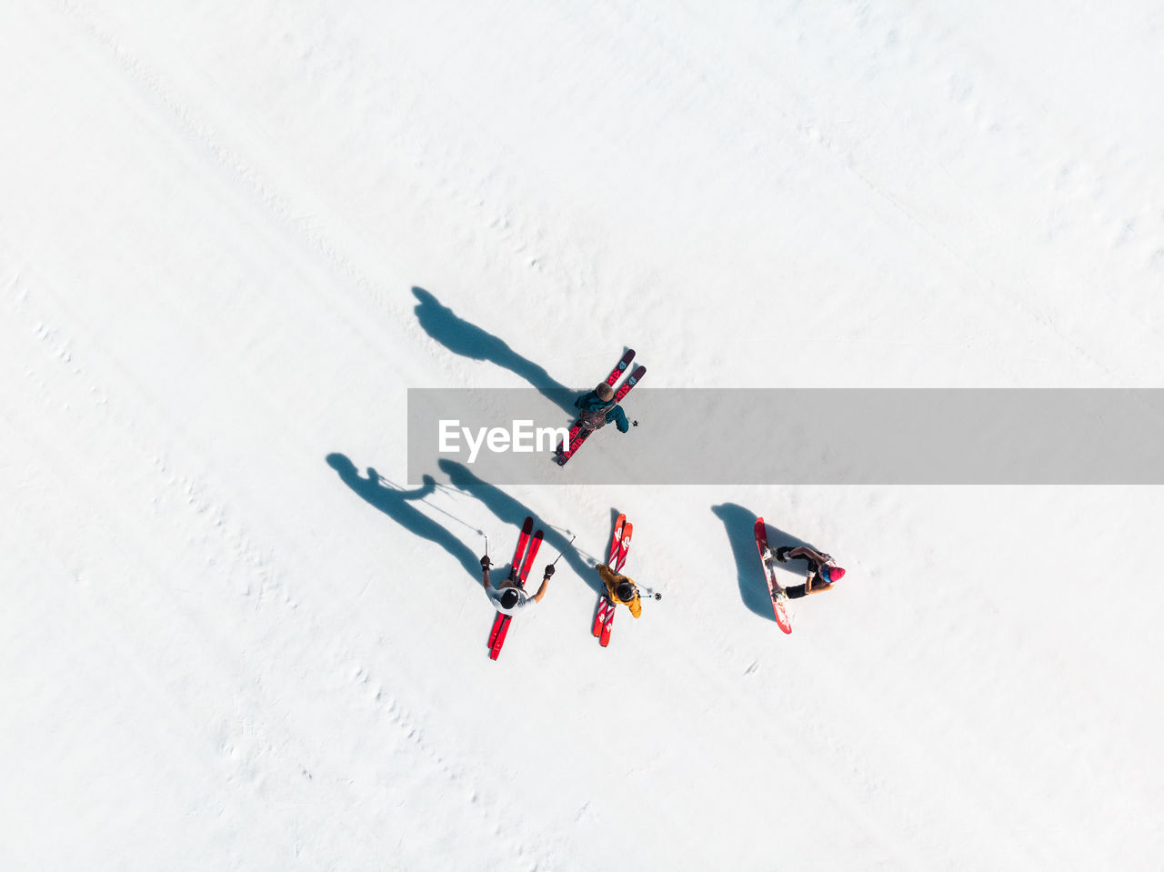 HIGH ANGLE VIEW OF PEOPLE SKIING ON FIELD