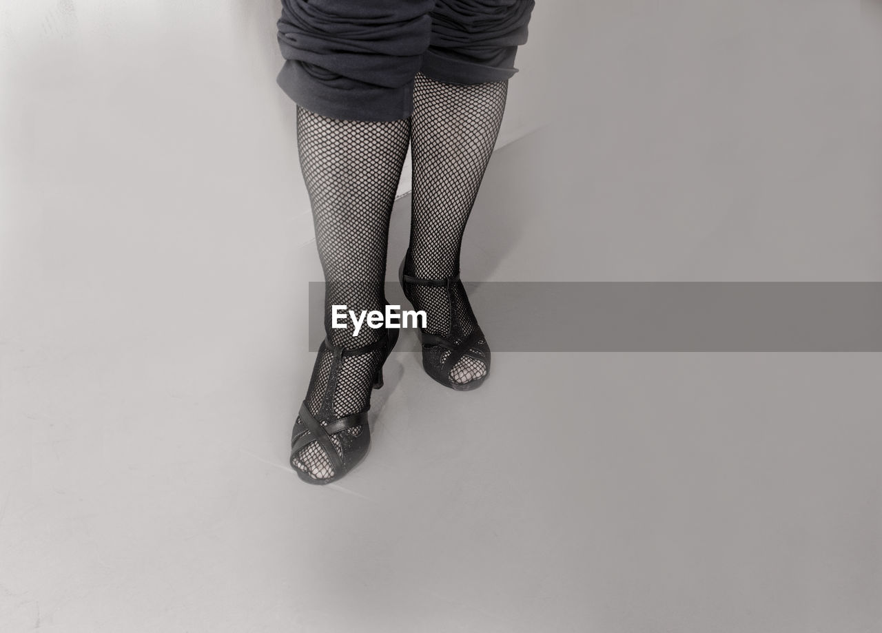 LOW SECTION OF WOMAN STANDING ON FLOOR