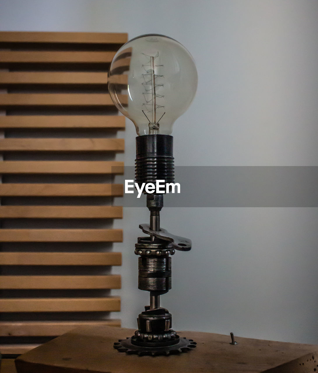 Close-up of light bulb on table against wall