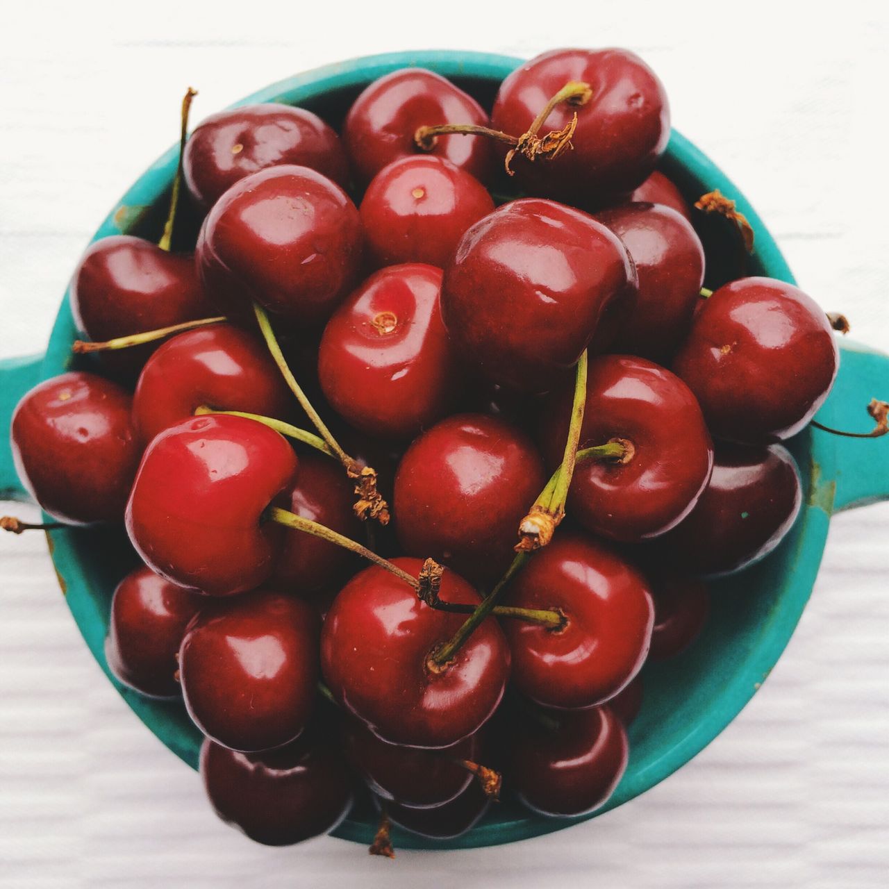 Directly above shot of fresh cherries in bowl on table