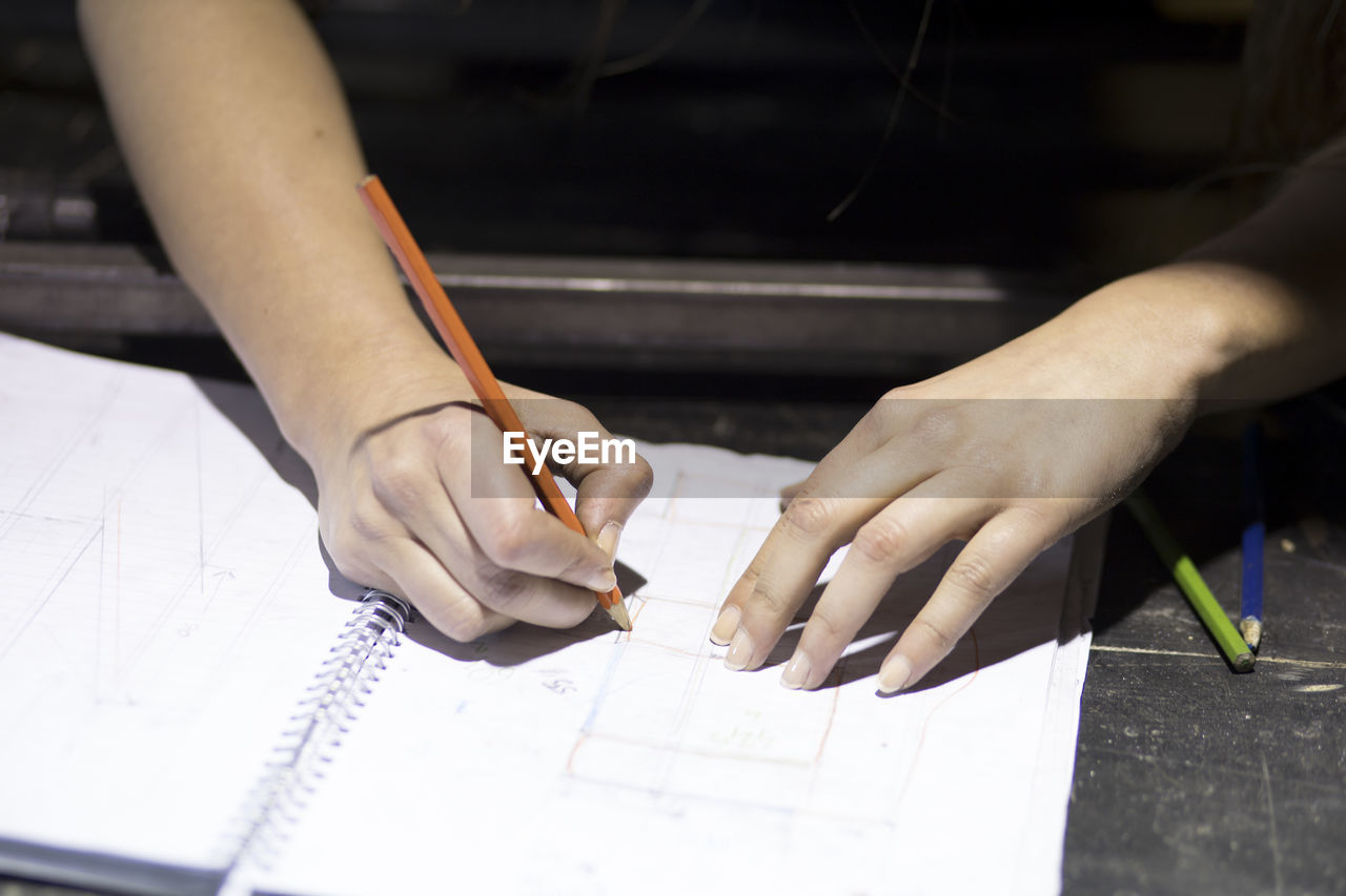 Midsection of man writing on table