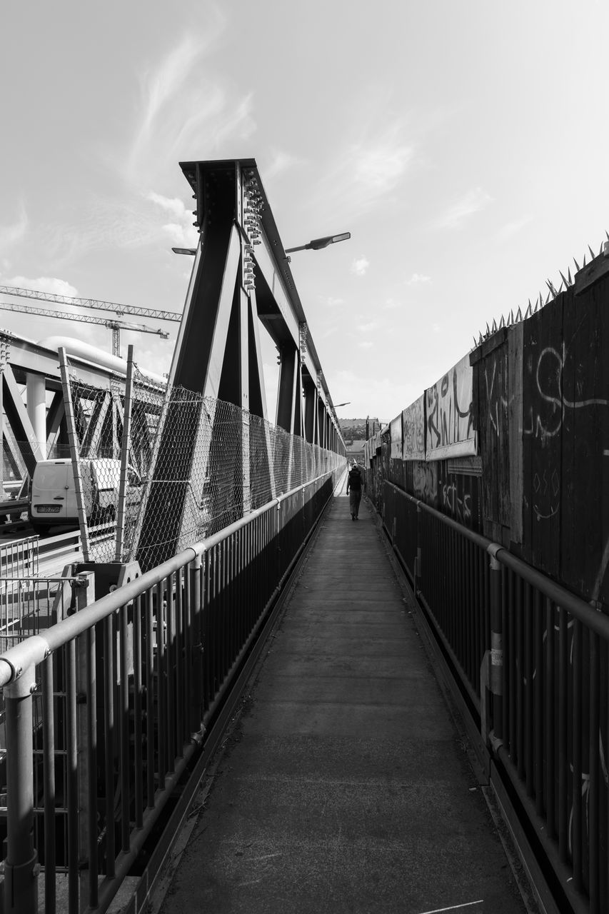 bridge, architecture, sky, built structure, transportation, black and white, monochrome, monochrome photography, cloud, nature, railing, the way forward, water, transport, travel destinations, black, city, outdoors, day, travel, white, footbridge, engineering, building exterior, diminishing perspective, suspension bridge, tourism