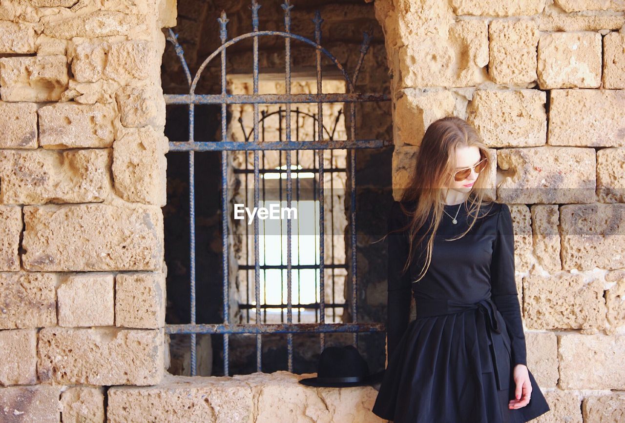 Young woman with long hair standing by window