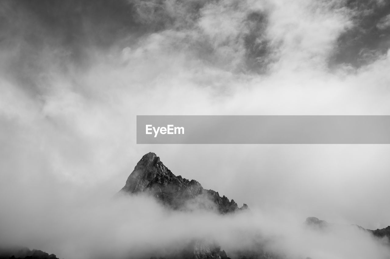 Low angle view of mountain against cloudy sky