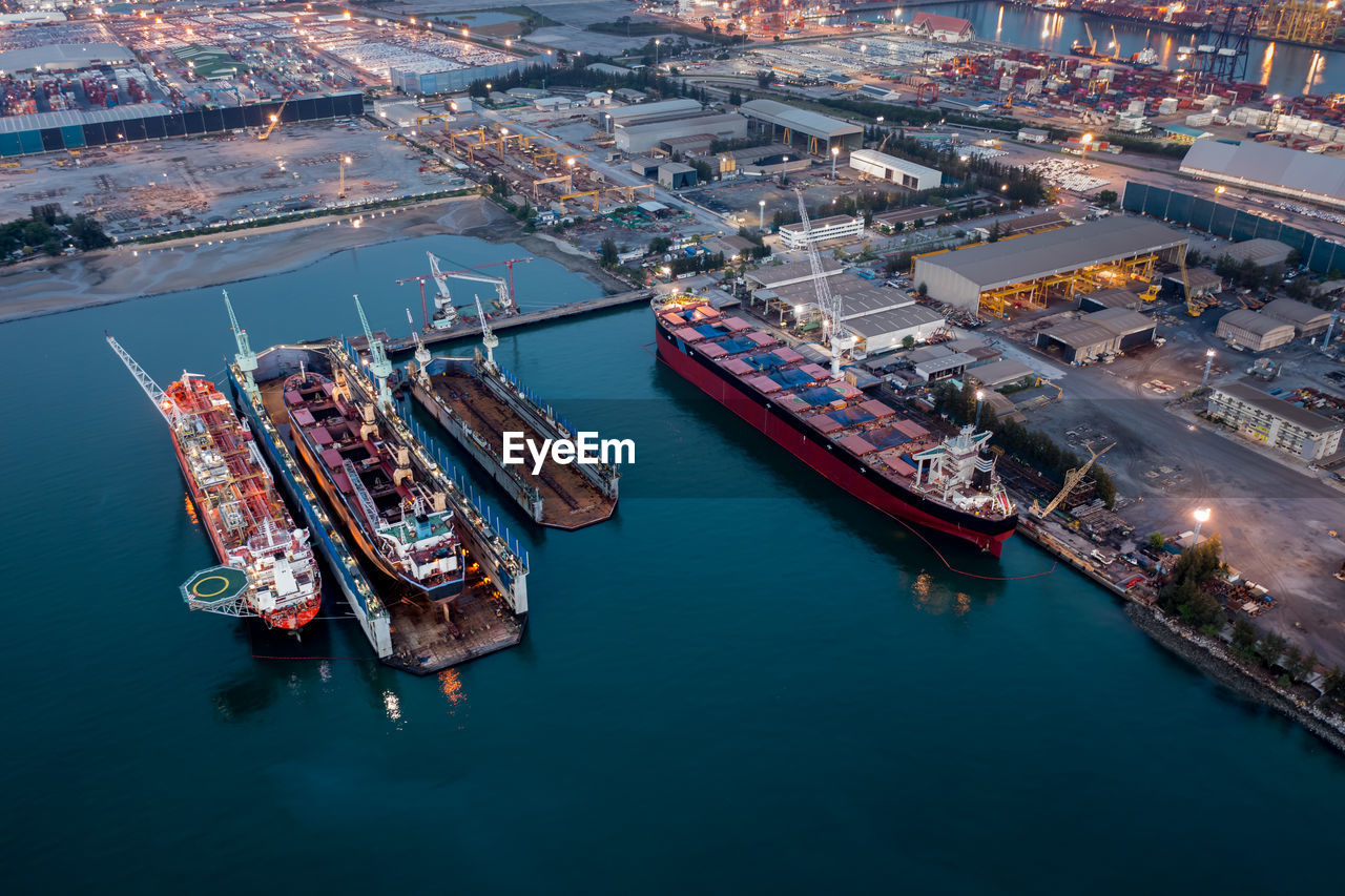 Aerial view container ship repair in shipyard at twilight over lighting . can use for shipping 