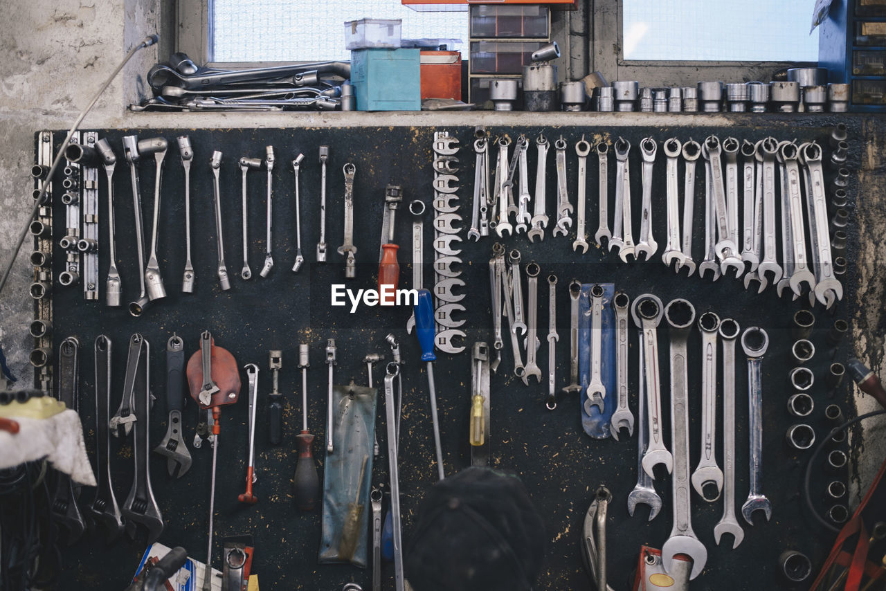 Various work tools hanging on wall at auto repair shop