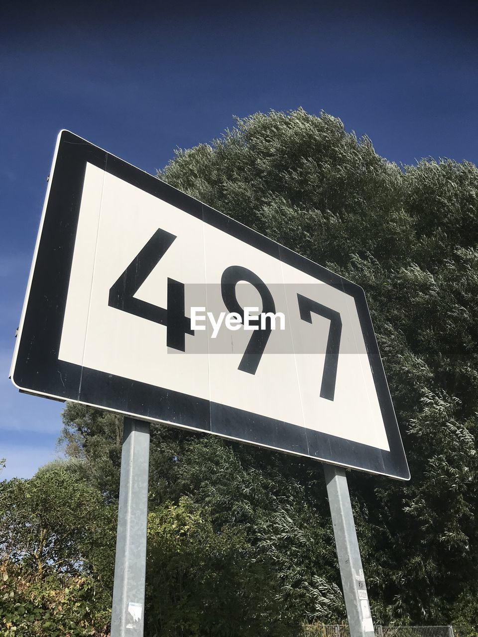 LOW ANGLE VIEW OF ROAD SIGN AGAINST BLUE SKY