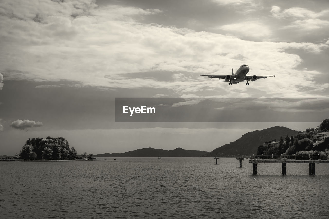 VIEW OF BIRDS FLYING OVER SEA AGAINST SKY