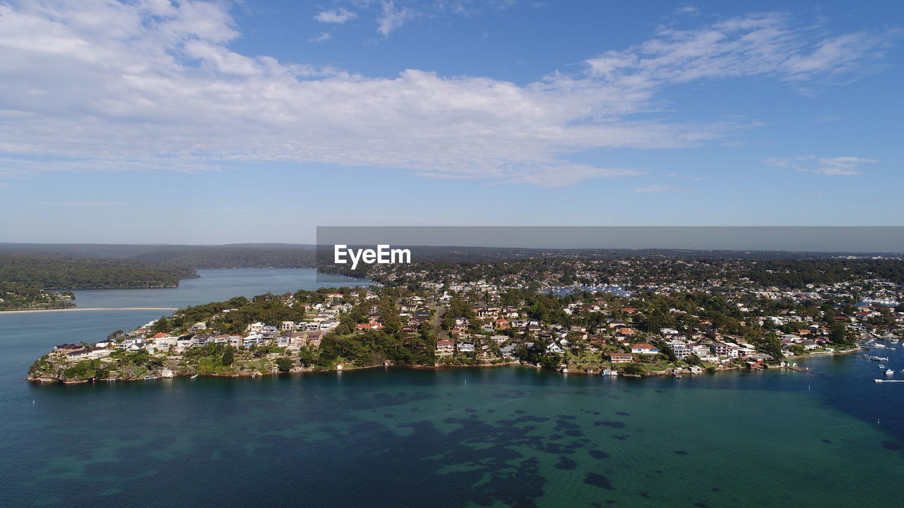 High angle view of townscape by sea against sky