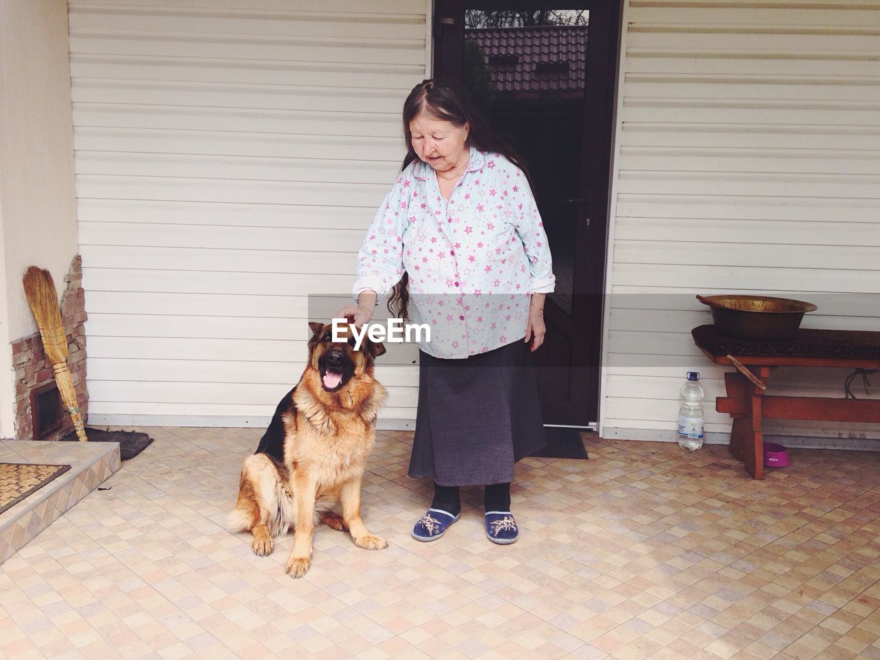 Senior woman with dog at front door