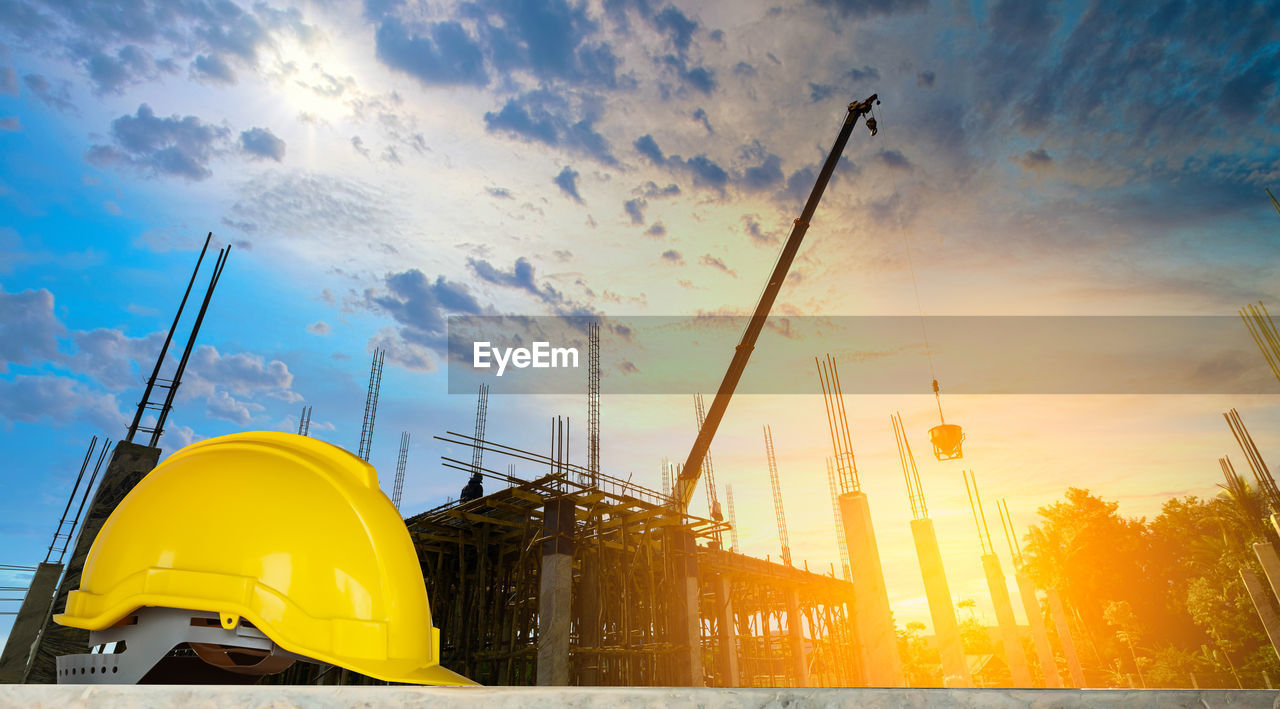 LOW ANGLE VIEW OF YELLOW CRANE AGAINST SKY